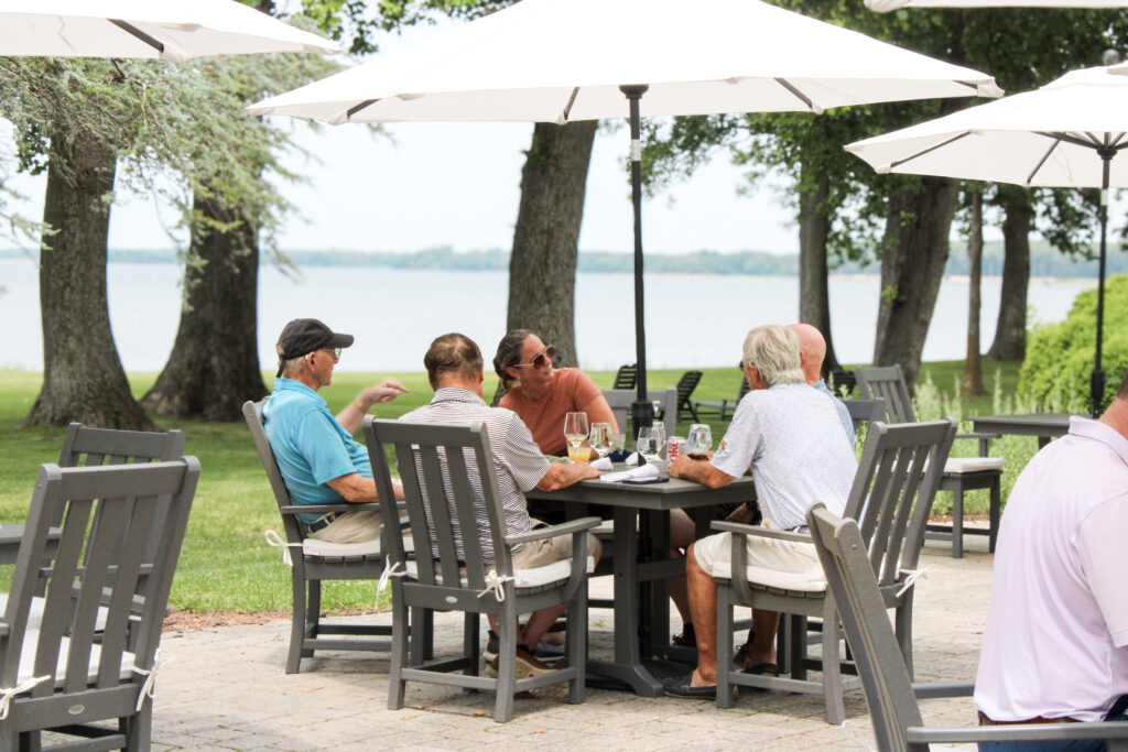 a group sits at a table and shares a meal at queenstown harbor golf resort