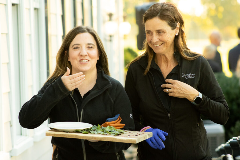 two members of the queenstown harbor food and beverage teen smile together