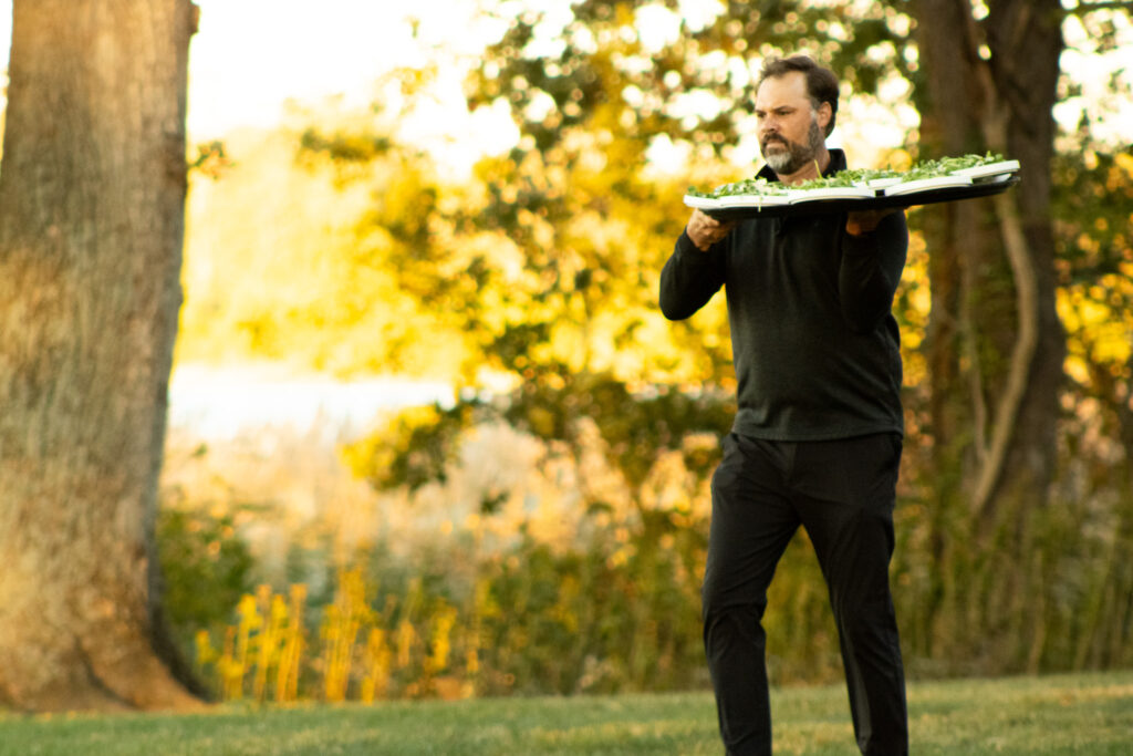 a man serves food on the queenstown harbor food and beverage team