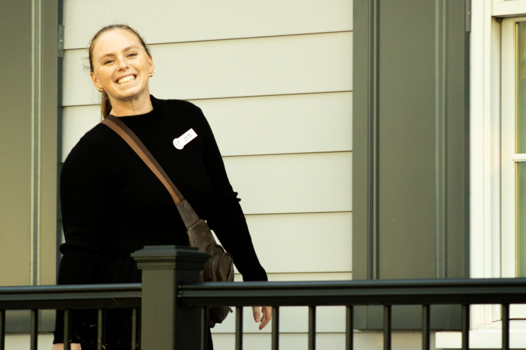 a woman who works at queenstown harbor golf resort smiles for a camera