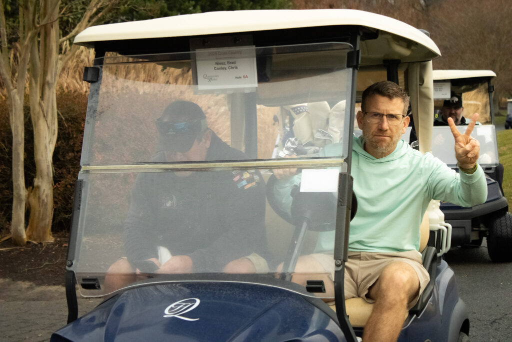 a man poses for a photo in a golf cart at queenstown harbor