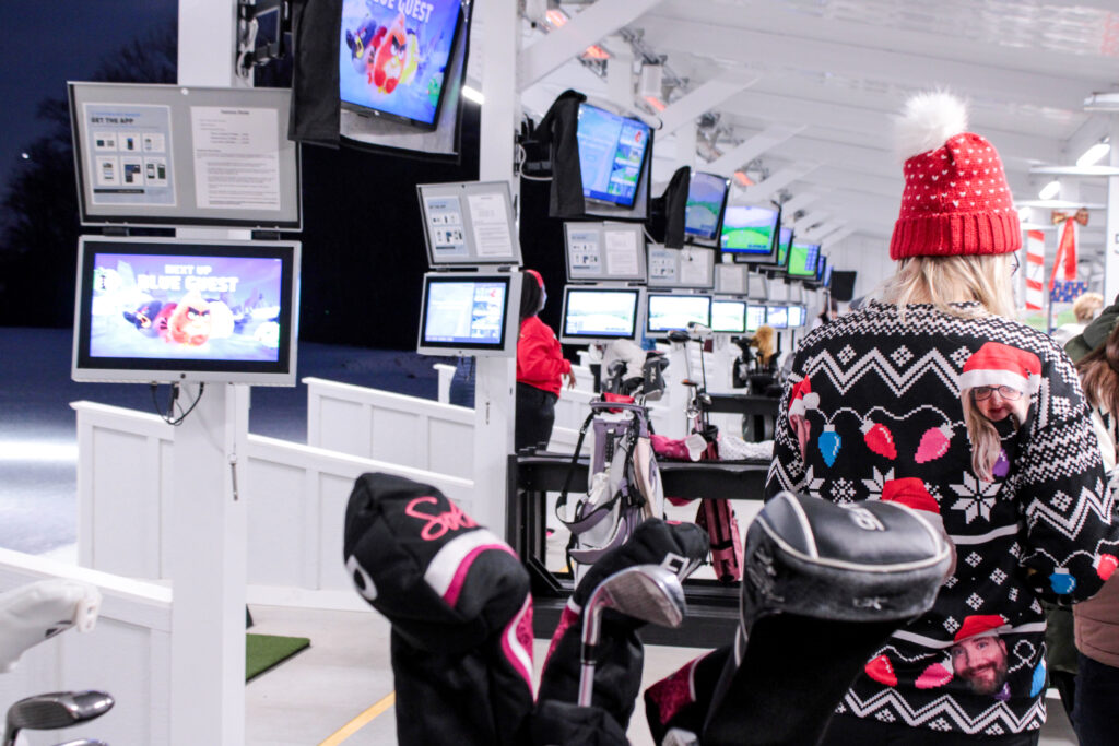 festive guests attend the toptracer driving range at queenstown harbor golf resort